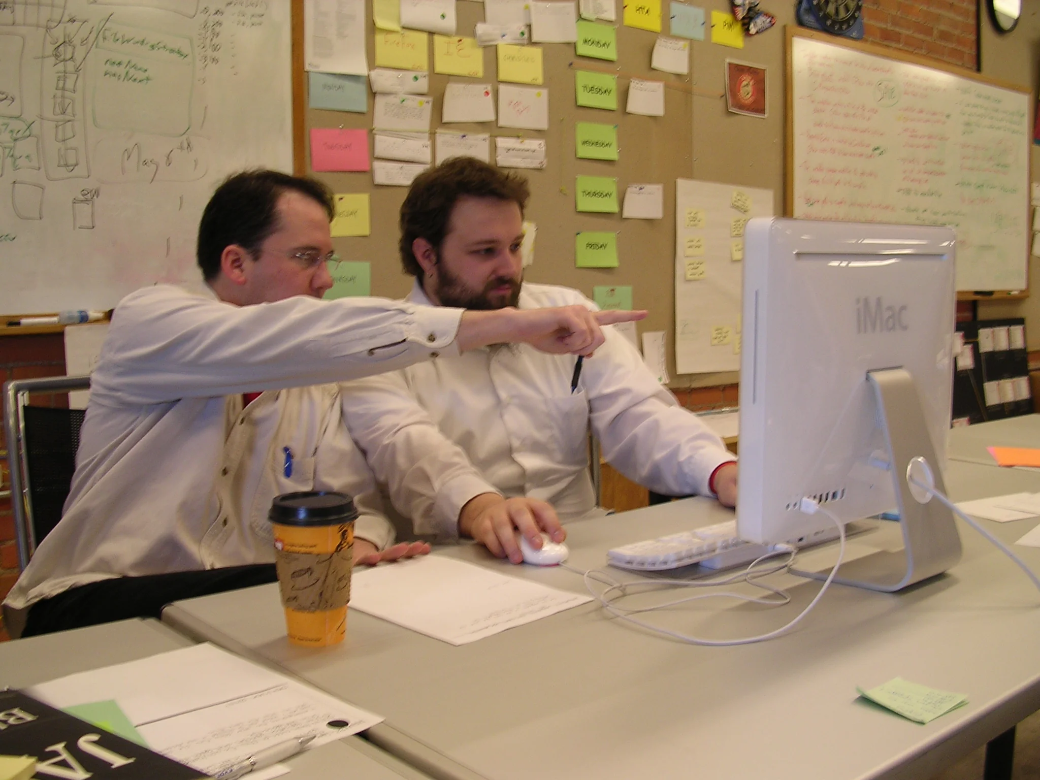 Two developers pair programming at a laptop
